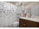 Cozy bathroom featuring a single sink vanity and a shower/tub with a floral curtain at 7750 Ridgelake Cir, Bradenton, FL 34203
