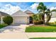 Inviting single-story home featuring a well-manicured lawn, two-car garage, and decorative front yard landscaping at 7750 Ridgelake Cir, Bradenton, FL 34203