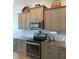 Gourmet kitchen with stainless steel appliances, granite countertops, and ample storage in modern, gray cabinetry at 7750 Ridgelake Cir, Bradenton, FL 34203