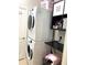 Close-up of the laundry area featuring a stacked washer/dryer unit and storage shelves at 7750 Ridgelake Cir, Bradenton, FL 34203