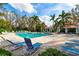 Community pool area featuring lounge chairs, palm trees, and covered seating areas for the residents at 7750 Ridgelake Cir, Bradenton, FL 34203