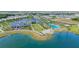 Stunning aerial view of a lakeside community featuring a pool, clubhouse, and meticulously landscaped grounds at 7983 Sandstar Way, Sarasota, FL 34240