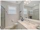 Bright bathroom with a glass shower, gray walls, vanity and a white marble countertop at 7983 Sandstar Way, Sarasota, FL 34240
