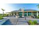 Elegant clubhouse exterior featuring a covered patio, fire pit, and comfortable seating areas at 7983 Sandstar Way, Sarasota, FL 34240