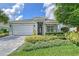 Charming single-story home with a meticulously landscaped front yard and a brick driveway at 7983 Sandstar Way, Sarasota, FL 34240