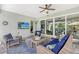 Relaxing screened lanai with comfortable wicker furniture and view through sliding glass doors at 7983 Sandstar Way, Sarasota, FL 34240