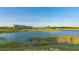 Scenic view of the pond and community clubhouse, showcasing the tranquil setting of the property at 7983 Sandstar Way, Sarasota, FL 34240