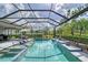 Inviting backyard pool with a screen enclosure, patio furniture, and landscaped surroundings at 7983 Sandstar Way, Sarasota, FL 34240