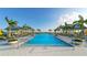 Beautiful community pool with cabanas, palm trees, and plenty of lounge chairs for residents at 7983 Sandstar Way, Sarasota, FL 34240
