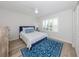 Bright bedroom with a blue accent rug and queen-size bed with a blue headboard at 821 Montrose Dr # 103, Venice, FL 34293