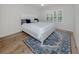 Bright bedroom with king bed, wood-look floors, and large window views at 821 Montrose Dr # 103, Venice, FL 34293