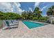 A sparkling community pool offers refreshing relaxation with lounge chairs on a brick patio surrounded by a white fence at 821 Montrose Dr # 103, Venice, FL 34293