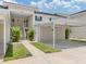 A clean condo building offers parking with carports and stairs with maintained landscaping at 821 Montrose Dr # 103, Venice, FL 34293