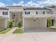 A bright condo building features covered parking and a well-maintained landscape with green grass and tropical trees at 821 Montrose Dr # 103, Venice, FL 34293