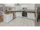 Stylish kitchen featuring stainless steel appliances, granite countertops, tile flooring, and white cabinetry at 821 Montrose Dr # 103, Venice, FL 34293