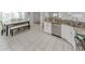 Bright kitchen featuring granite counters, white cabinets, stainless steel appliances, and dining area at 821 Montrose Dr # 103, Venice, FL 34293