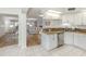 Bright kitchen featuring granite counters, white cabinets, stainless steel appliances, and opening to the living room at 821 Montrose Dr # 103, Venice, FL 34293