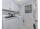 Laundry room with front loading washer and dryer, with overhead cabinets at 821 Montrose Dr # 103, Venice, FL 34293