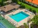 An aerial view of a community pool surrounded by lounge chairs and a tennis court at 8240 Cypress Lake Dr, Sarasota, FL 34243