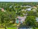 Aerial view of a home with a screened pool nestled in a lush, tree-filled neighborhood with a nearby lake at 8240 Cypress Lake Dr, Sarasota, FL 34243