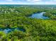 An aerial view of lush, green trees and vegetation surrounding a lake at 8240 Cypress Lake Dr, Sarasota, FL 34243