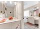 Bathroom with double sinks, a large mirror, and a view into the adjacent bathtub area at 8240 Cypress Lake Dr, Sarasota, FL 34243