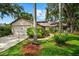 Charming single-story home with a well-manicured lawn, mature trees, and an inviting entrance and two car garage at 8240 Cypress Lake Dr, Sarasota, FL 34243