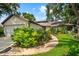 Charming single-story home featuring lush landscaping and a welcoming walkway leading to the front entrance at 8240 Cypress Lake Dr, Sarasota, FL 34243