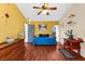 Living room with a daybed, hardwood floors, and bright yellow accent wall at 8240 Cypress Lake Dr, Sarasota, FL 34243
