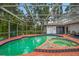 Spacious screened-in pool and spa area featuring vibrant turquoise water, a tiled border, and a well-maintained deck at 8240 Cypress Lake Dr, Sarasota, FL 34243