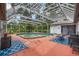 An outdoor screened-in pool area including a pool, a hot tub, patio furniture, and blue patterned rugs at 8240 Cypress Lake Dr, Sarasota, FL 34243