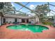 Inviting screened-in pool and spa with tile accents and ample seating space, perfect for outdoor relaxation and entertaining at 8240 Cypress Lake Dr, Sarasota, FL 34243