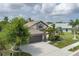 An elevated view of a home with mature trees and landscaping including a three car driveway and stone facade at 9236 Raes Creek Pl, Palmetto, FL 34221