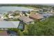 An aerial view of houses with backyard pools bordering a lush golf course and lake at 9236 Raes Creek Pl, Palmetto, FL 34221