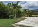 Lush backyard featuring a tiled patio, verdant trees, and well-maintained landscaping, creating a private retreat at 9236 Raes Creek Pl, Palmetto, FL 34221