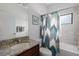 Clean bathroom featuring tiled walls, tub, and a framed 'Wash Your Hands' print on the wall at 9236 Raes Creek Pl, Palmetto, FL 34221