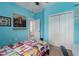 Bright bedroom painted light blue with a large closet and a decorative horse print on the wall at 9236 Raes Creek Pl, Palmetto, FL 34221