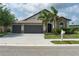 Charming single-Gathering home featuring a 3-car garage, stone accents, and tropical landscaping at 9236 Raes Creek Pl, Palmetto, FL 34221