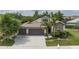 Charming home showcasing a well-manicured lawn, mature landscaping, and an attached two-car garage at 9236 Raes Creek Pl, Palmetto, FL 34221