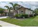 Beautifully landscaped home featuring stone accents, a well-maintained lawn, and a spacious three-car garage at 9236 Raes Creek Pl, Palmetto, FL 34221