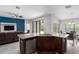Open concept kitchen features a granite island, dark wood cabinets, stainless steel appliances, and adjoining living room at 9236 Raes Creek Pl, Palmetto, FL 34221