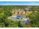 Aerial view of a park with bocce ball courts, picnic benches, a playground, and gazebo with lush trees and landscaping at 12261 Stuart Dr, Venice, FL 34293