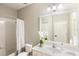 Bathroom vanity with framed mirror, framed faucet, single sink and white floral arrangement on top at 12261 Stuart Dr, Venice, FL 34293