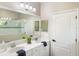 Bright bathroom features double vanity, white cabinets, a large mirror, and walk-in shower at 12261 Stuart Dr, Venice, FL 34293