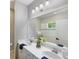 Bright bathroom features double vanity, white cabinets, a large mirror, and walk-in shower at 12261 Stuart Dr, Venice, FL 34293