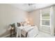 Neutral bedroom featuring a window, white trim, ceiling fan, and neutral decor at 12261 Stuart Dr, Venice, FL 34293