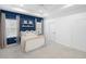 Bright bedroom features a tray ceiling, blue accent wall, two windows, and neutral furnishings at 12261 Stuart Dr, Venice, FL 34293
