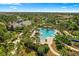 Expansive community pool with a slide, surrounded by palm trees and lush landscaping, perfect for Gathering fun at 12261 Stuart Dr, Venice, FL 34293