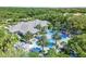 Overhead view of community pool showcasing unique design, lounge areas, palm trees, and well-maintained landscaping at 12261 Stuart Dr, Venice, FL 34293
