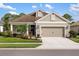 Exterior elevation of home featuring a tidy front lawn, walkway, 2-car garage and lush landscaping at 12261 Stuart Dr, Venice, FL 34293